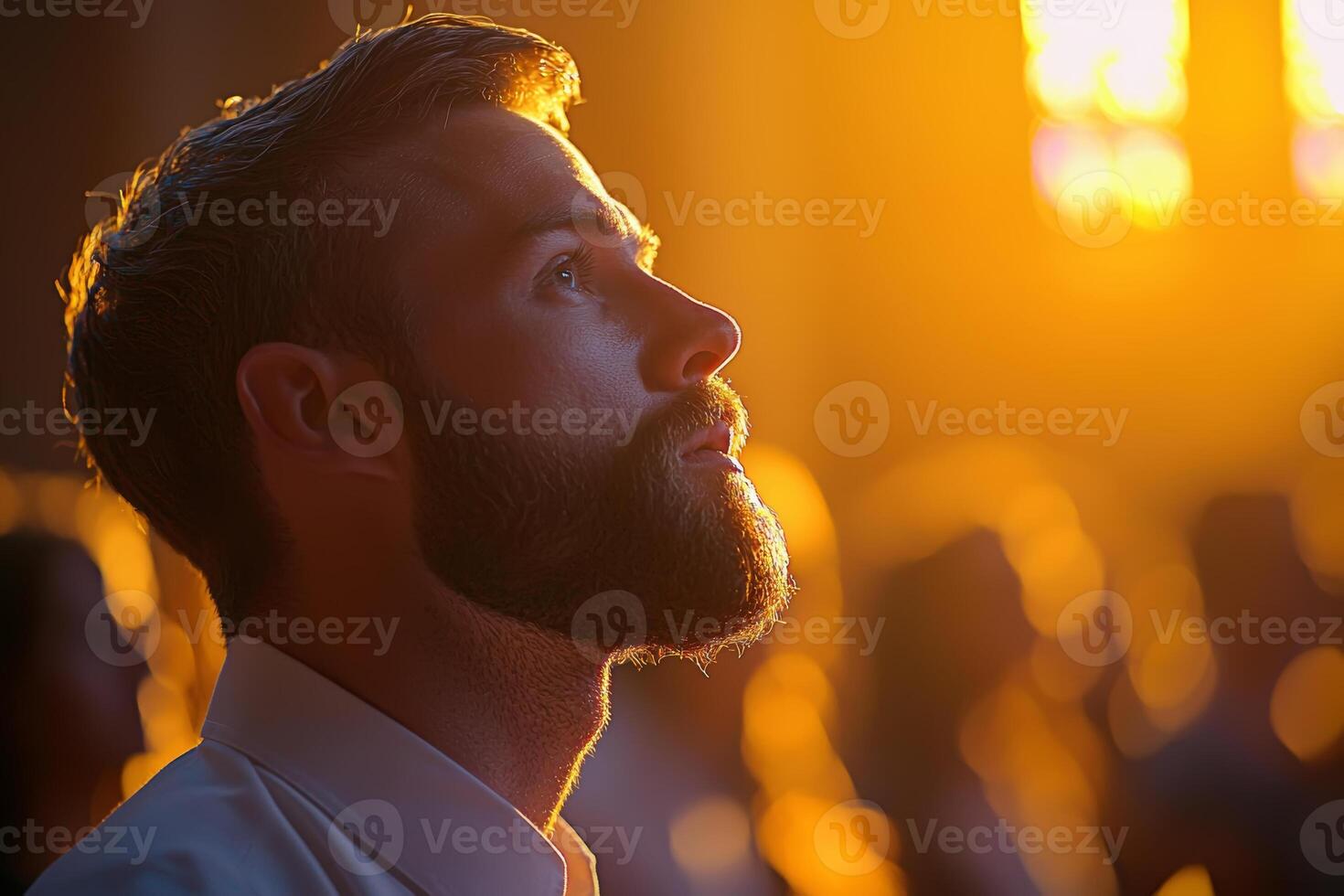 A man gazes thoughtfully upwards during a sunset service in a historic cathedral filled with warm light and a reflective atmosphere photo