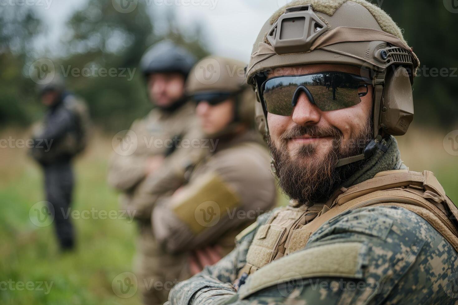 Military personnel in tactical gear participate in training exercises outdoors during a cloudy day in a forested area photo