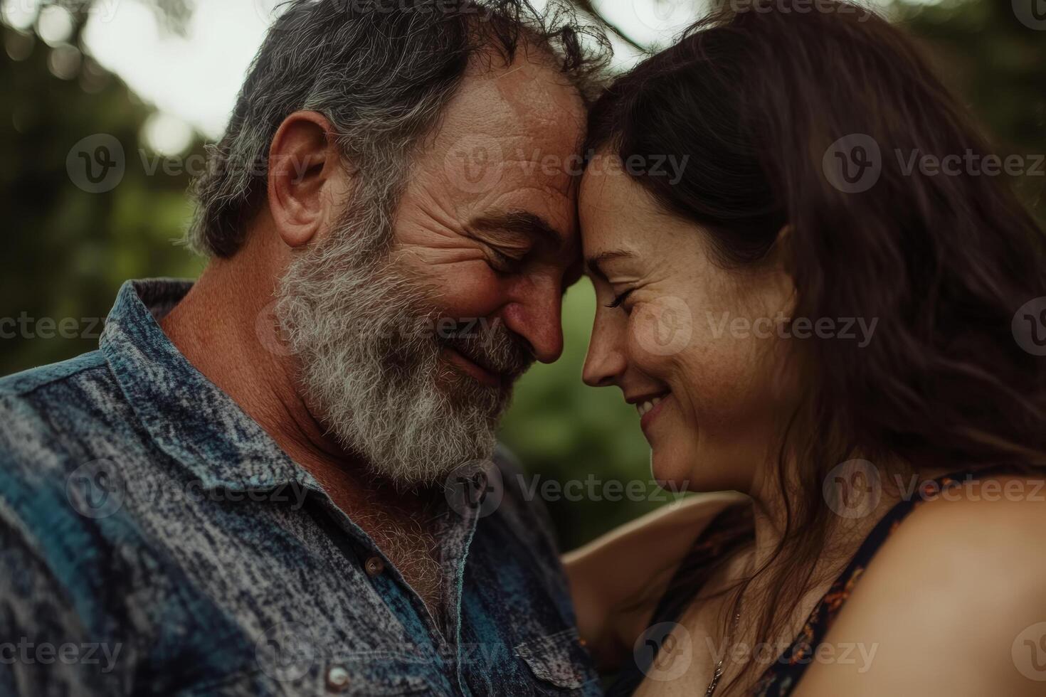 Tender moment shared between a couple during a sunny outdoor gathering in nature, showcasing love and connection photo