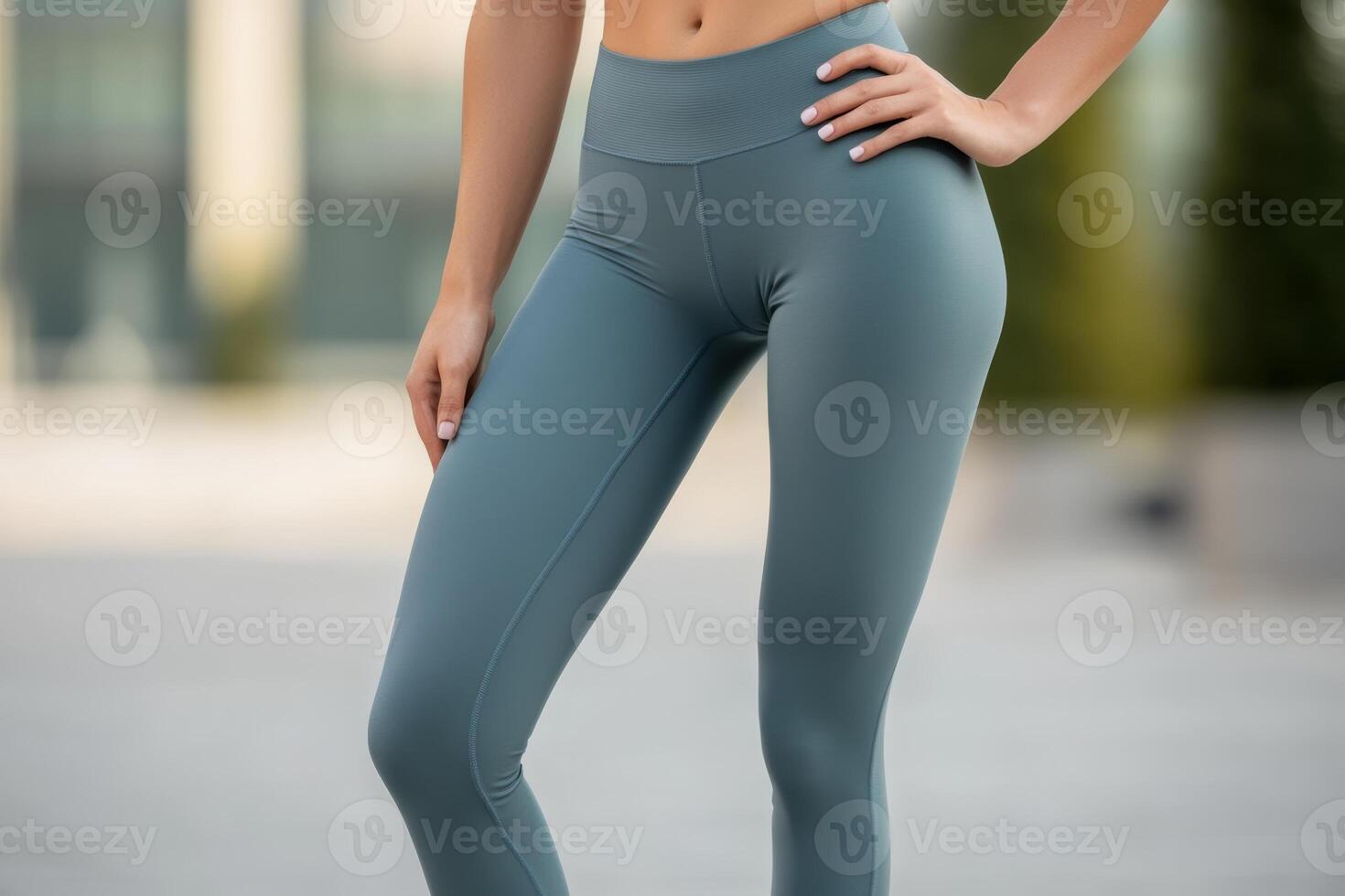 A woman practicing fitness outdoors in comfortable athletic leggings on a sunny day in a modern urban setting photo