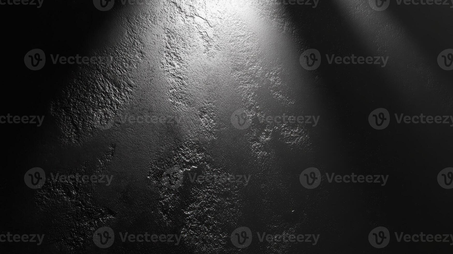Textured black concrete surface illuminated by spotlight with subtle shadows photo