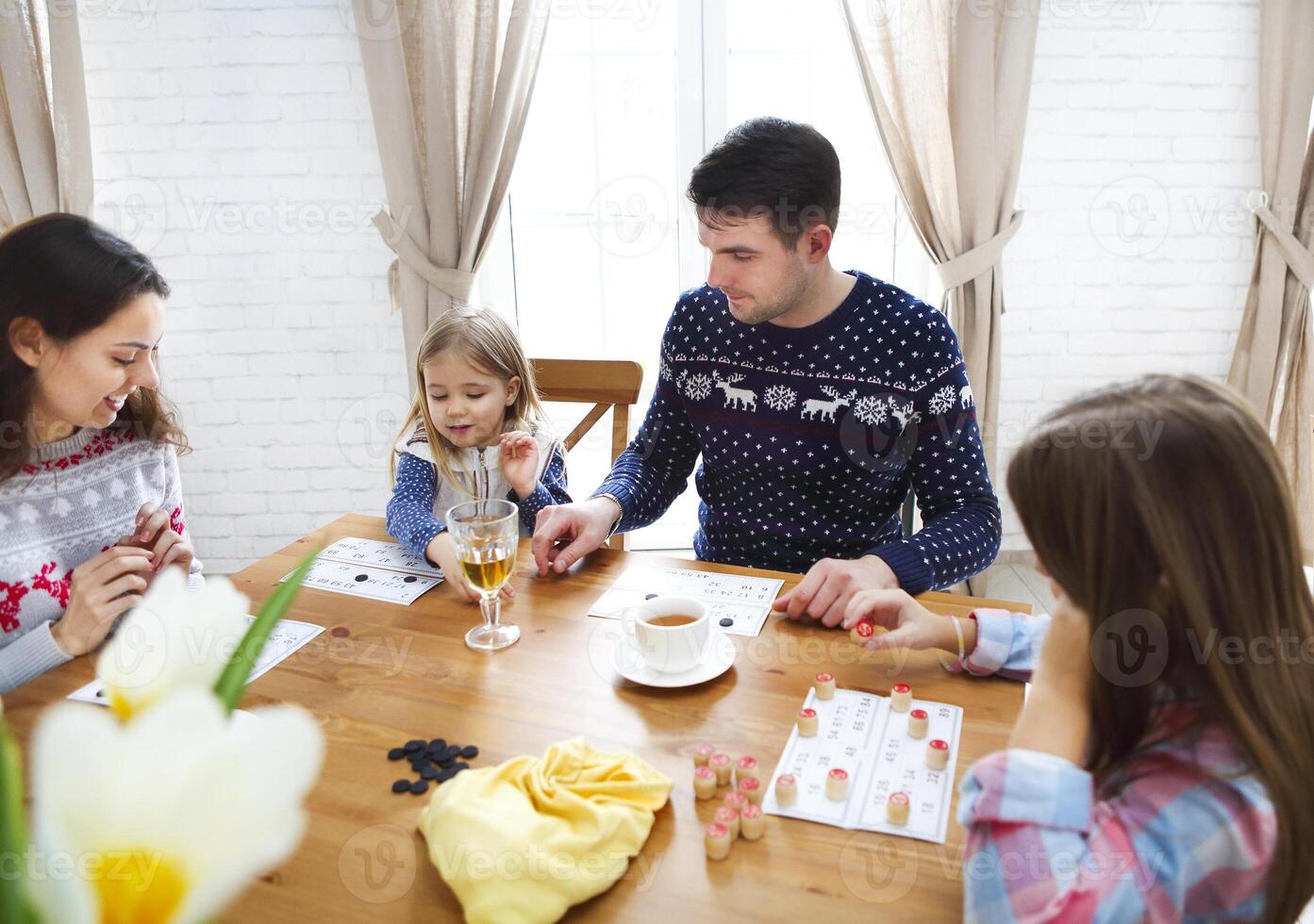 Happy young family plaing board game, winter time photo