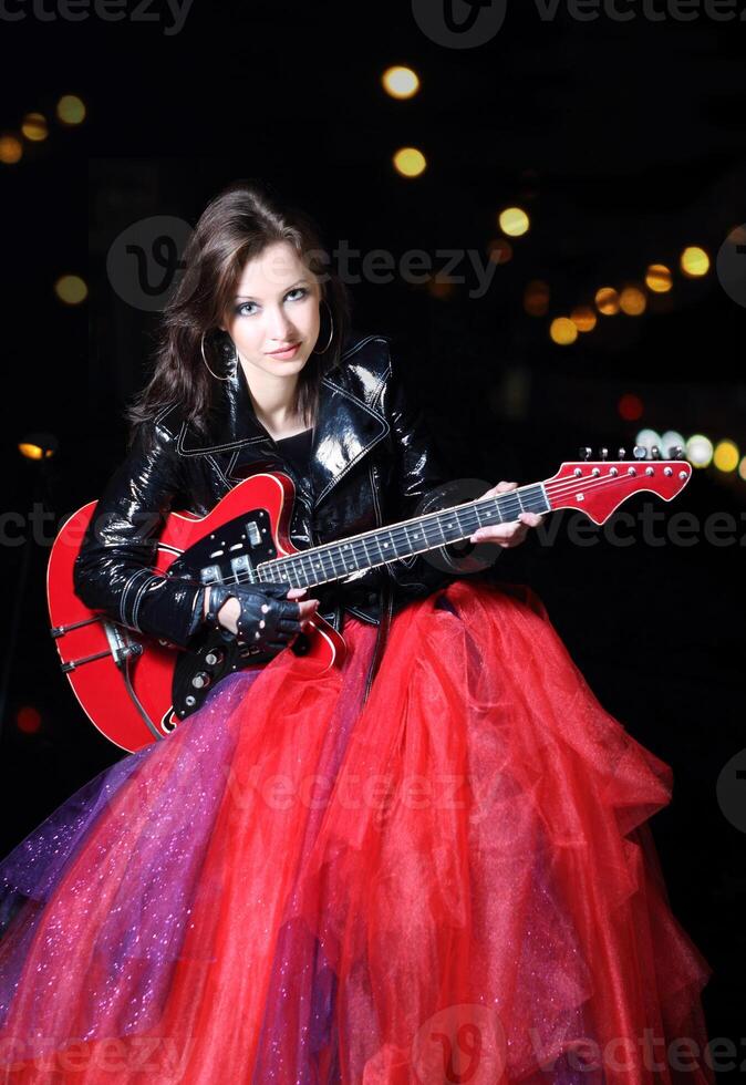 Guitar player girl in the dark night photo