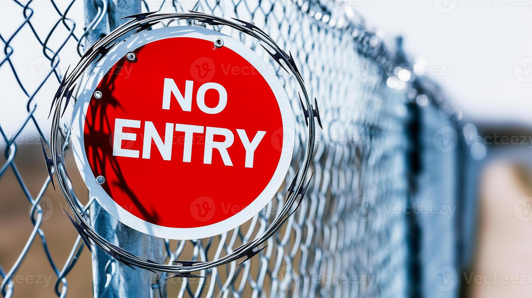 NO ENTRY warning sign on fence with barbed wire. Concept of illegal immigration control and security photo