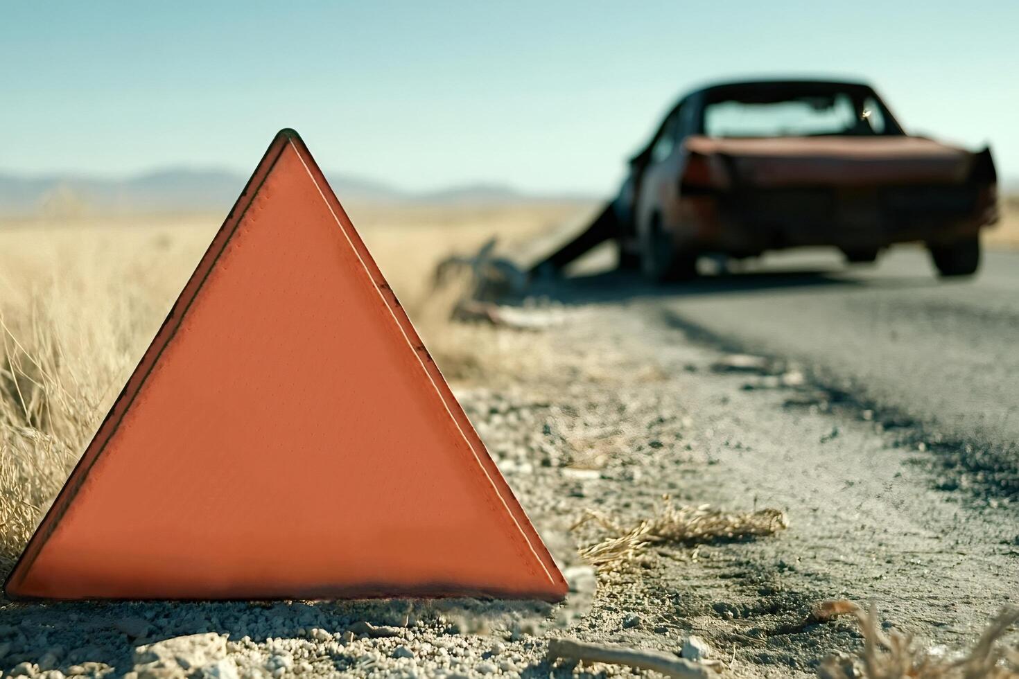 Warning triangle sign behind broken car on desert road photo