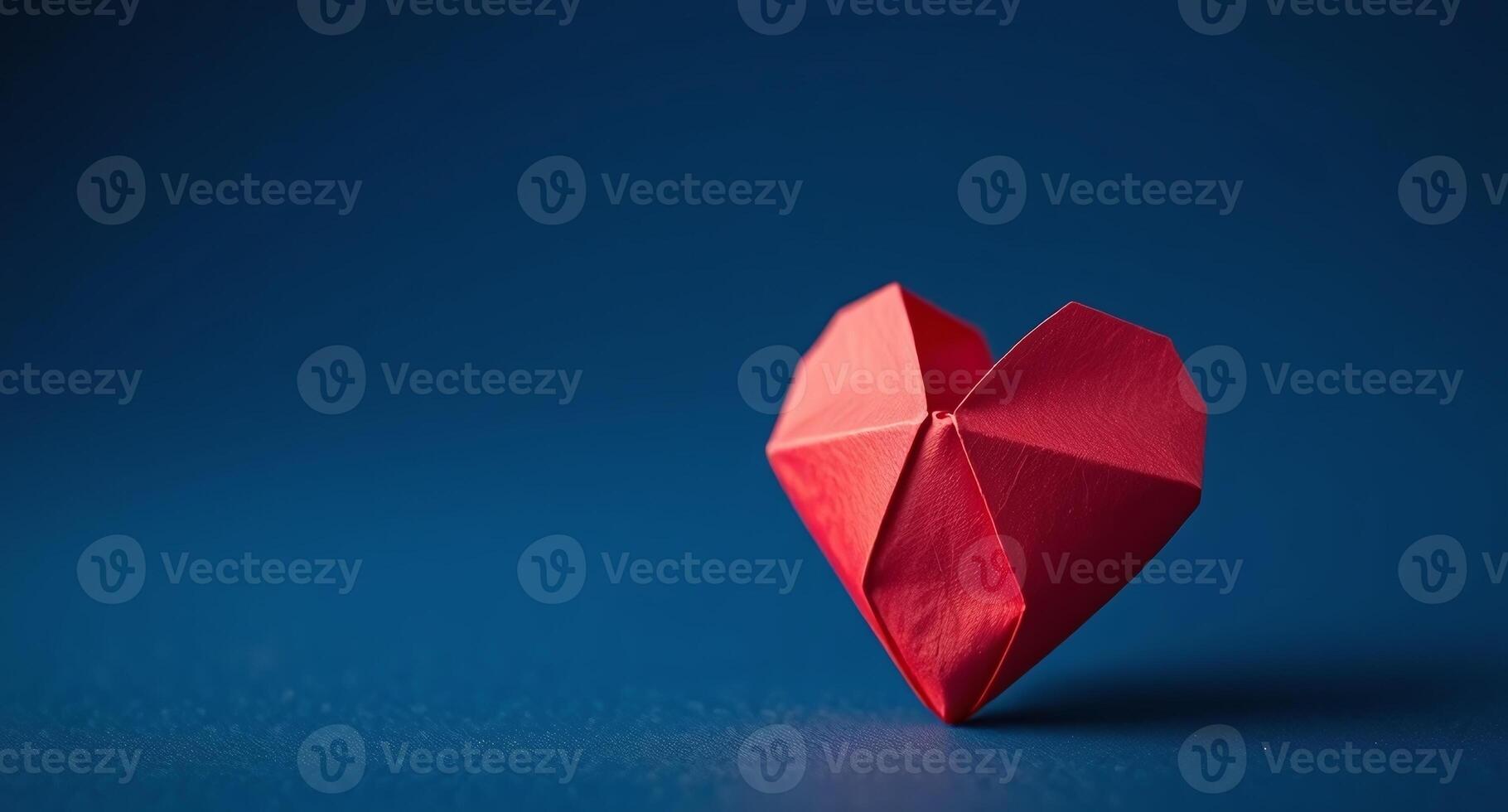 a red origami heart on a blue background photo