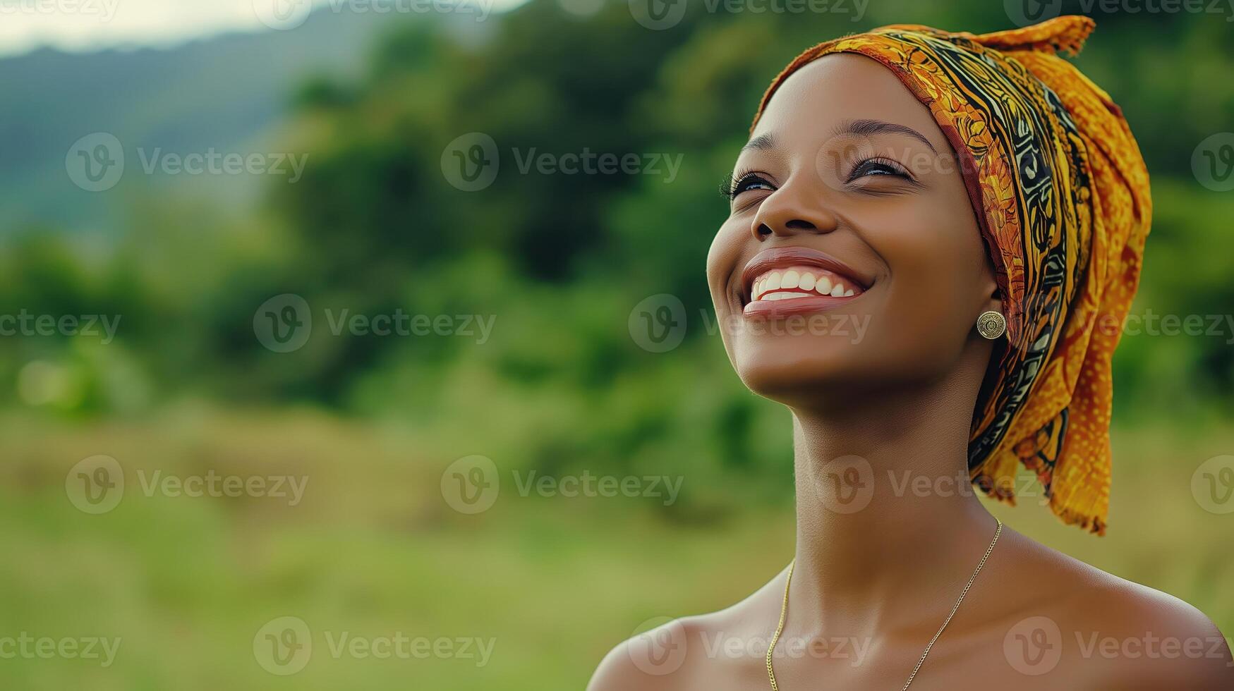 Smiling Black woman in headscarf standing in green field. International Day of Happiness. Copy space photo