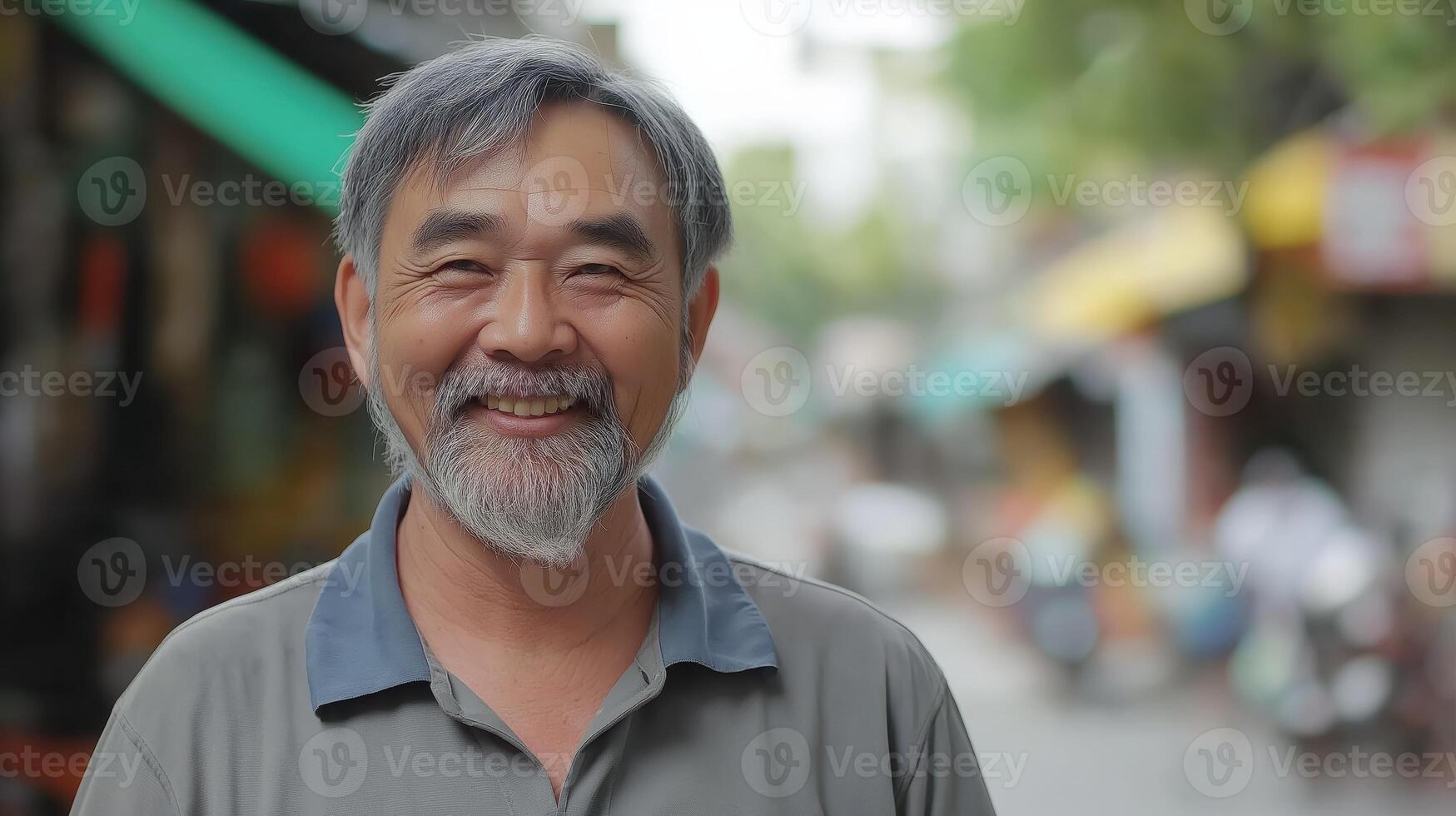 Middle-aged man smiling warmly, standing outdoors with blurred street background photo