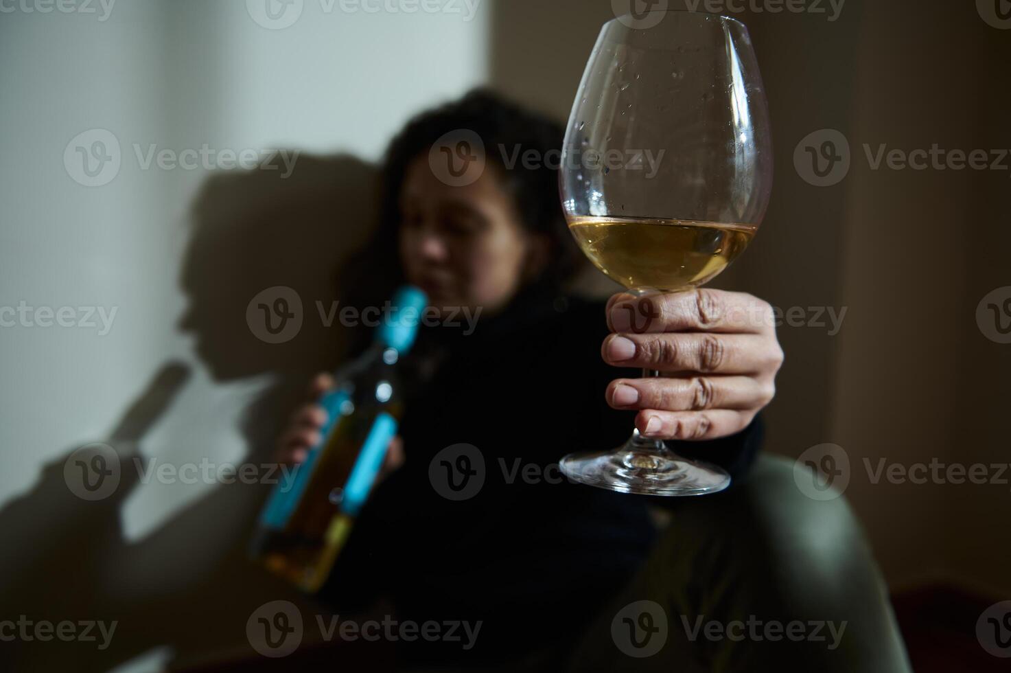 Close-up view of a wine glass held in focus with blurred background photo