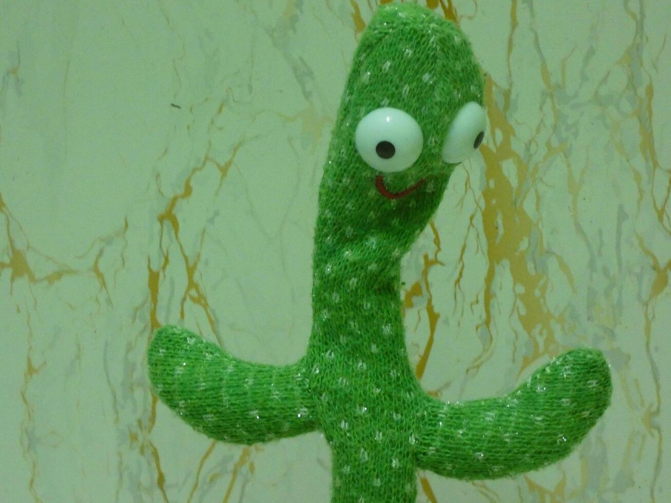 The toy cactus stood brightly on the shelf, made of soft fabric and decorated with colorful patterns, bringing joy to everyone who saw it. photo