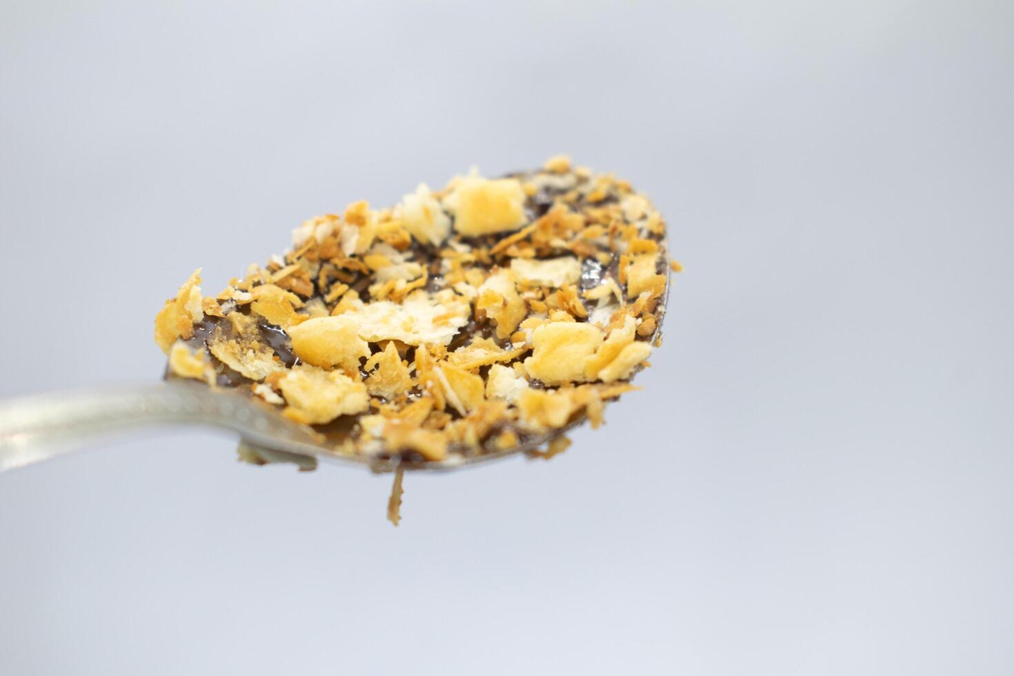 Bread crumbs stuck to spoon on white background photo