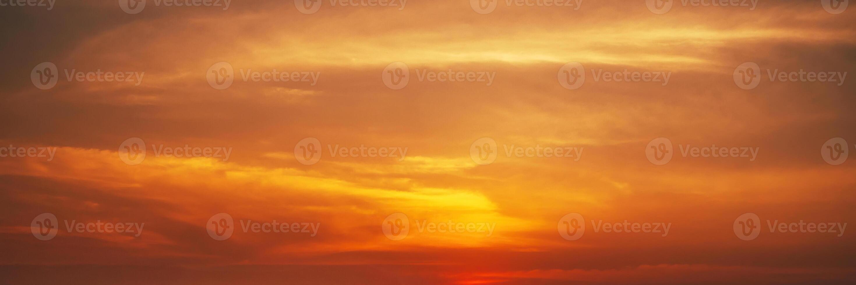 Panorama with orange sunset in cloudy sky with clouds. Background with sky at sunrise photo