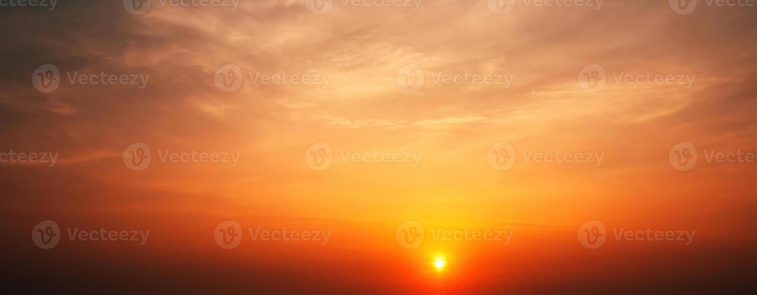 Panorama with an orange sunset and sun in cloudy sky with clouds. Background with sky at sunrise photo
