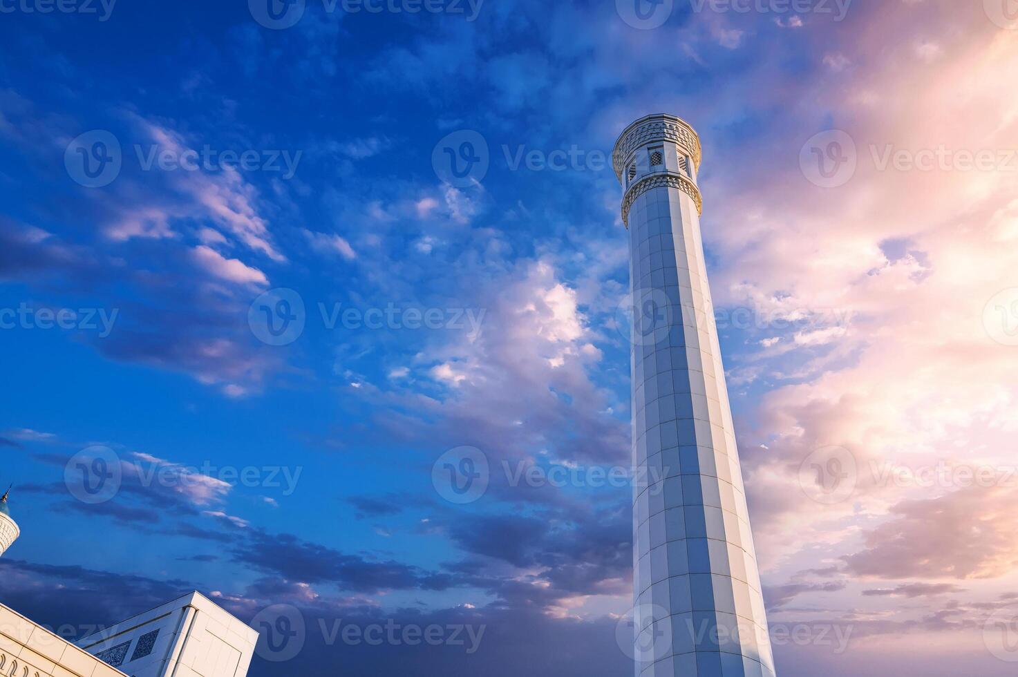 white minaret of modern new Islamic Masjid Minor Mosque in Tashkent in Uzbekistan on background of beautiful sky photo
