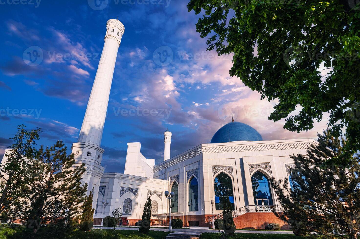 exterior of modern white Islamic Masjid Minor Mosque in Tashkent in Uzbekistan on background of blue sunset sky in summer photo