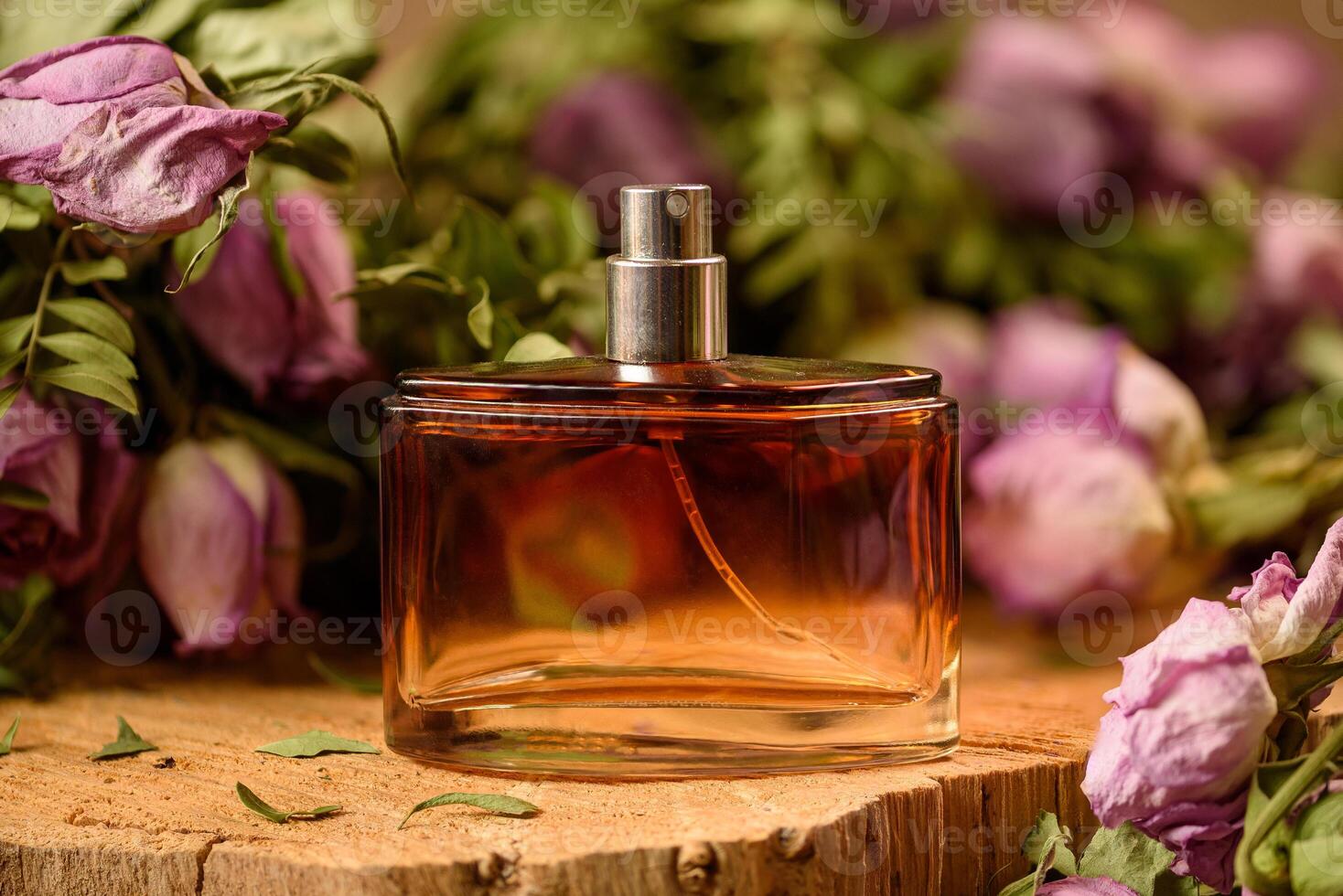 A bottle of perfume among withered flowers, standing on a tree cut photo