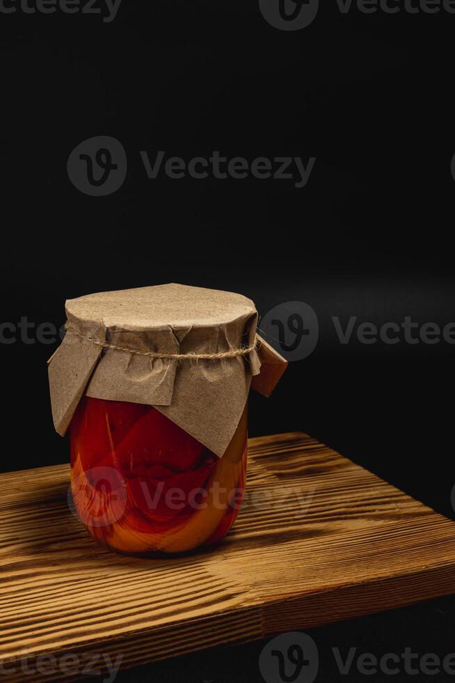 Canned food jar with homemade pickled vegetables on wooden surface photo