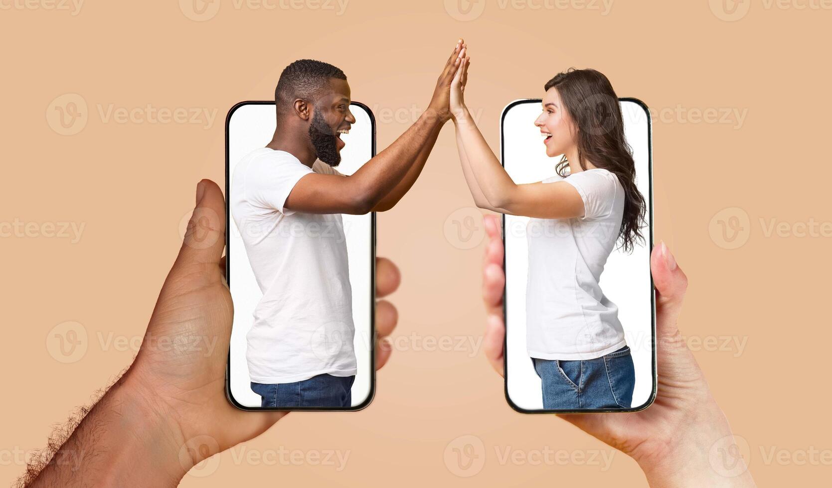 A couple engages with each other using smartphones, their hands touching through screens, showcasing modern communication in their relationship. photo