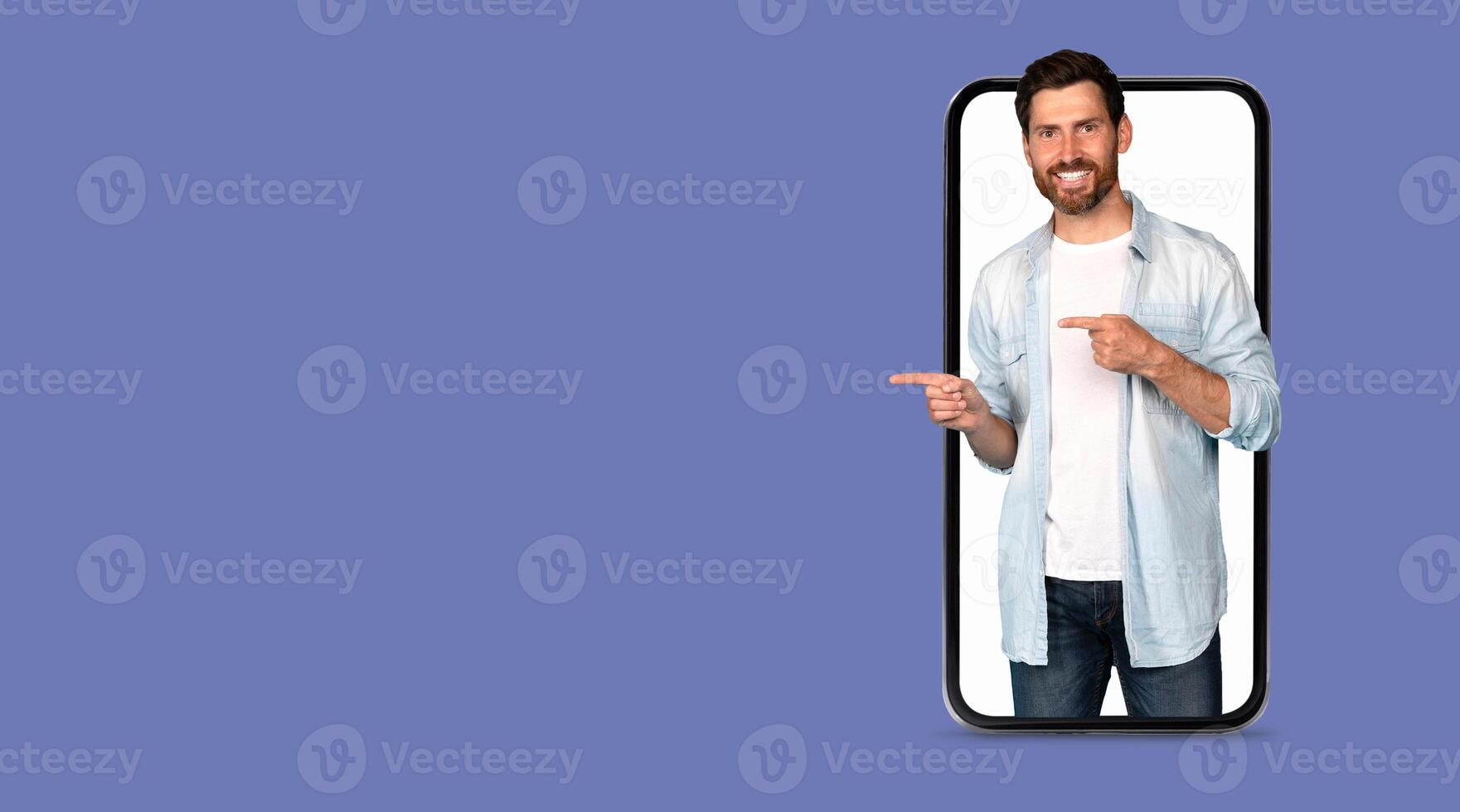 A person showcases a large smartphone screen while pointing, highlighting social media applications. The isolated background emphasizes modern communication technology. photo