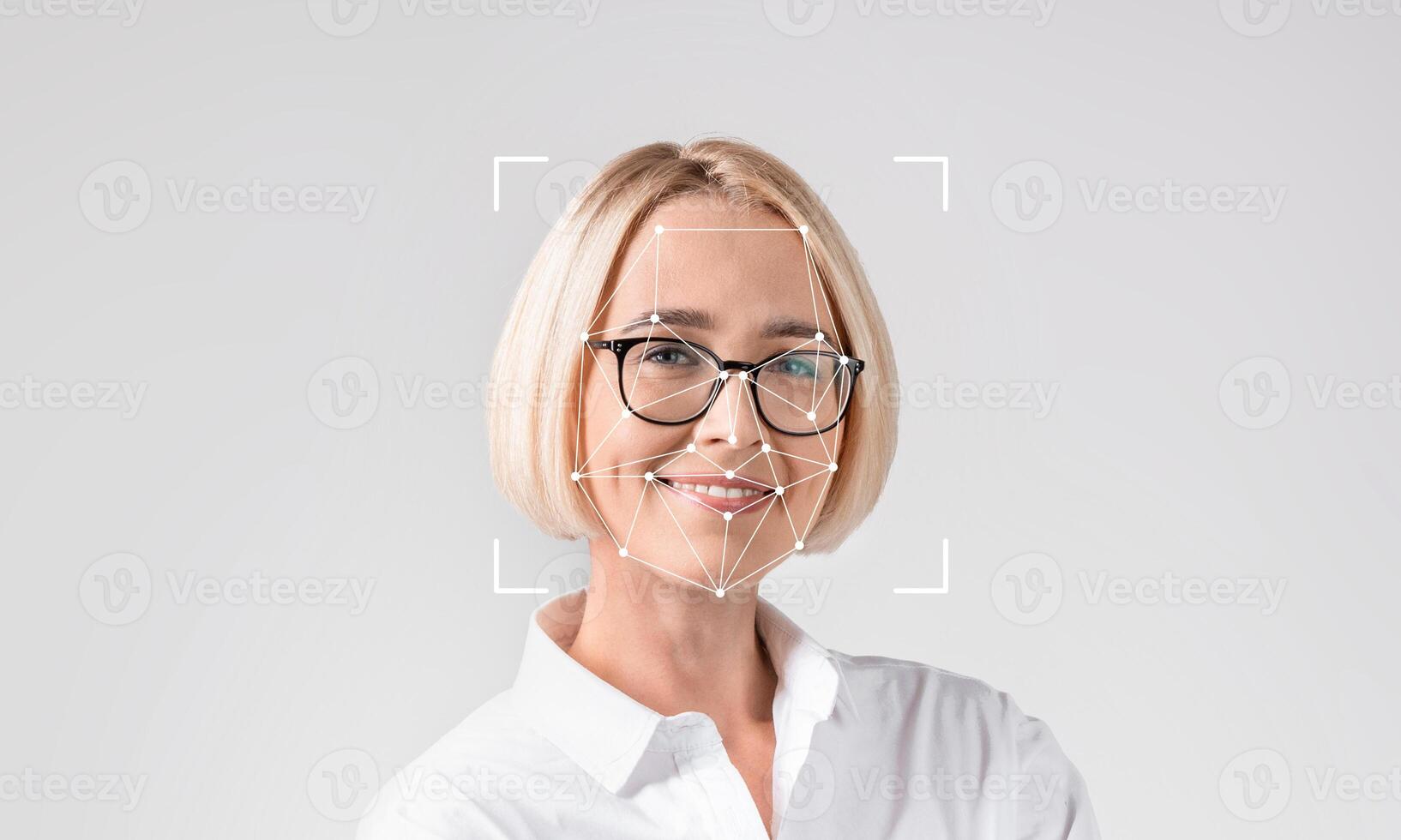 A woman smiles while being analyzed by facial recognition technology. This image highlights advancements in ID technology and how it is used for identification purposes in various fields. photo