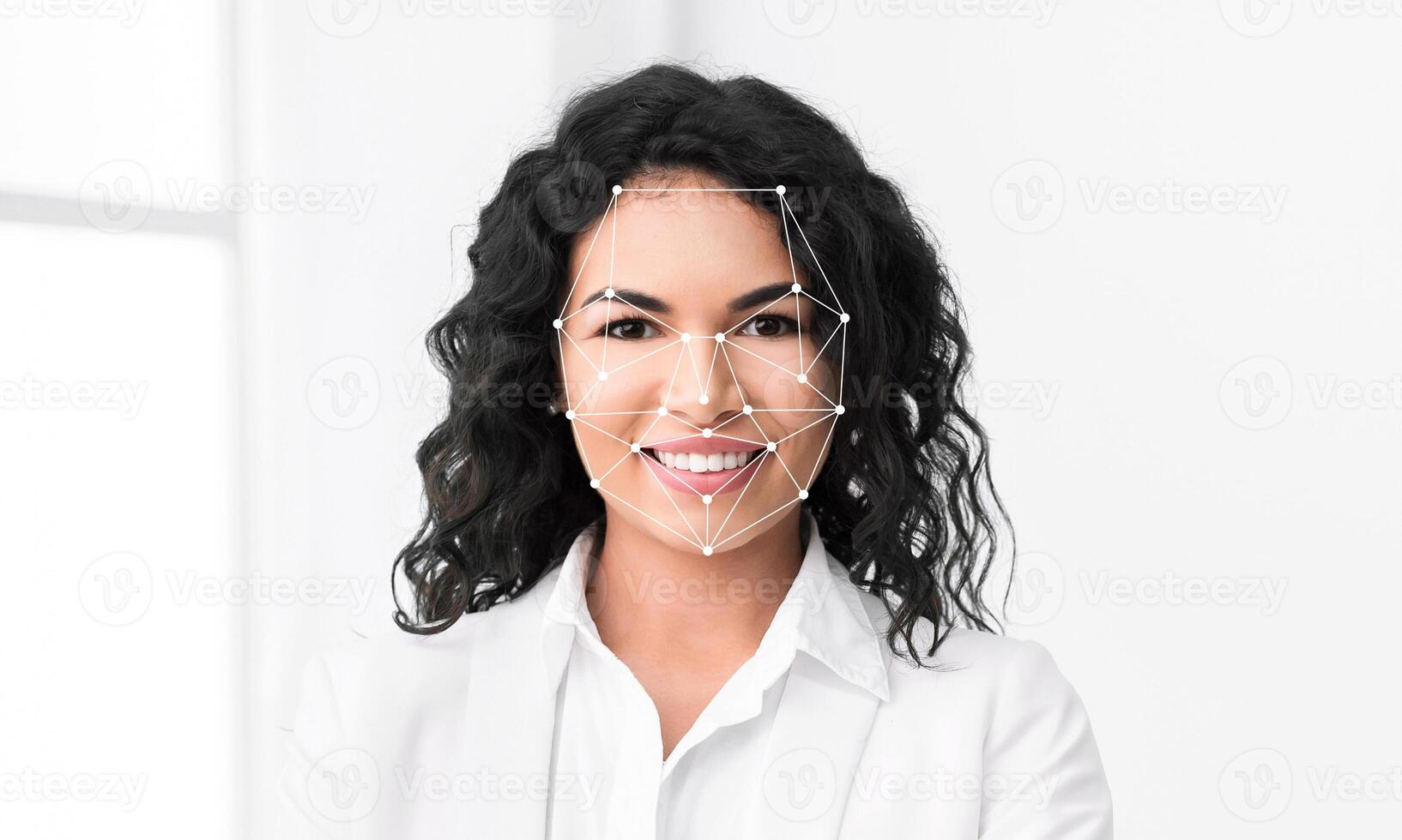 A woman with curly hair smiles confidently while facial identification technology maps her features. The background is bright and minimalistic, emphasizing her expression. photo