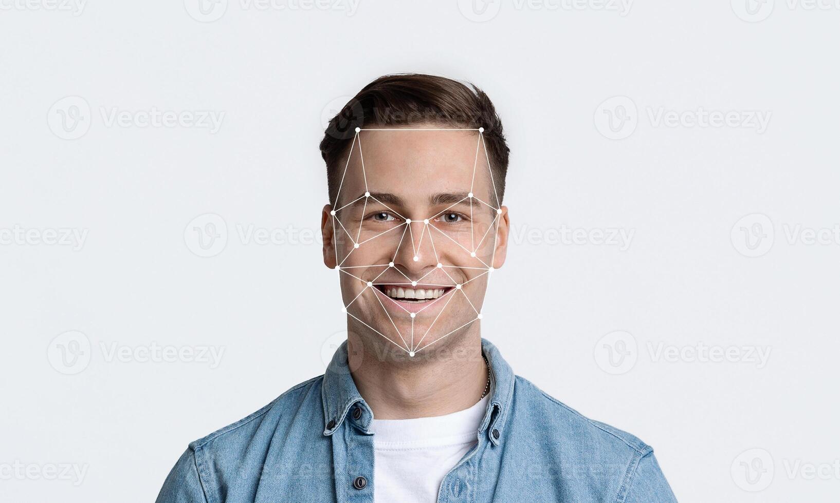 Smiling young man is featured against a plain background, demonstrating facial recognition technology with geometric lines outlining his face, emphasizing identification capabilities. photo