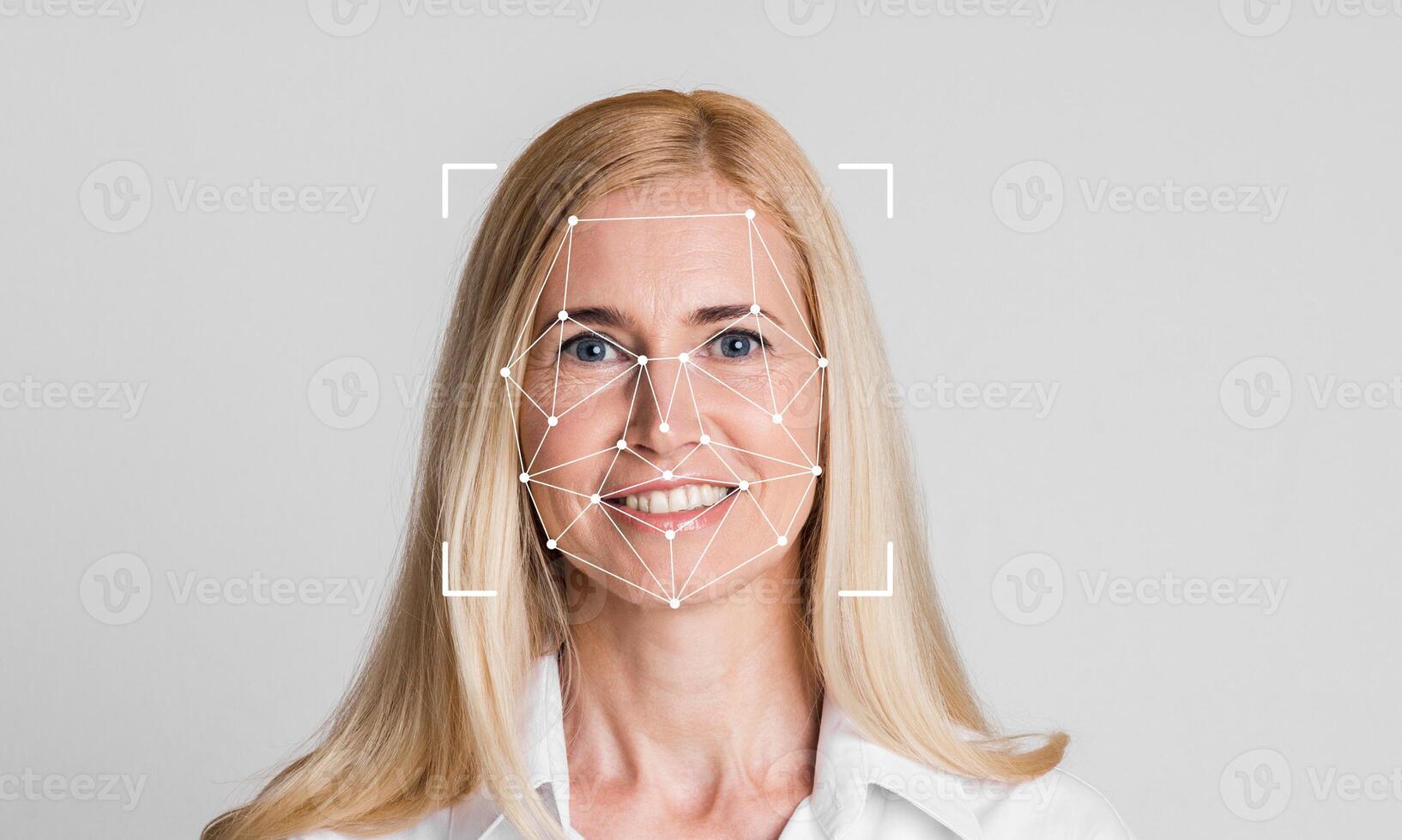 A woman smiling with facial recognition technology overlay on her face. The background is plain and light, emphasizing the subject's features and the tech aspect of identification. photo