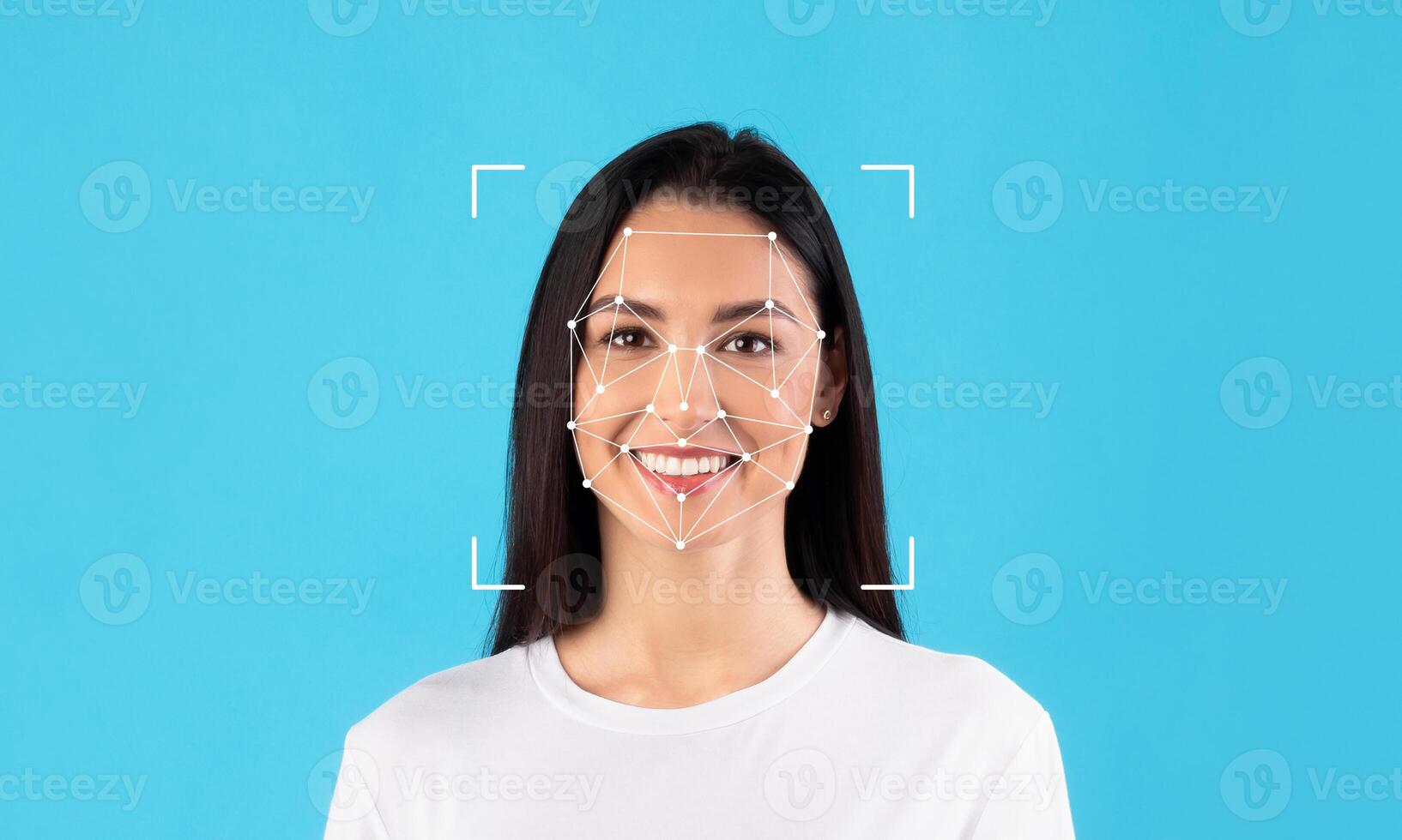 A woman with long dark hair smiles as facial recognition technology analyzes her features. The bright blue background enhances her expression, highlighting the innovative ID technology in action. photo
