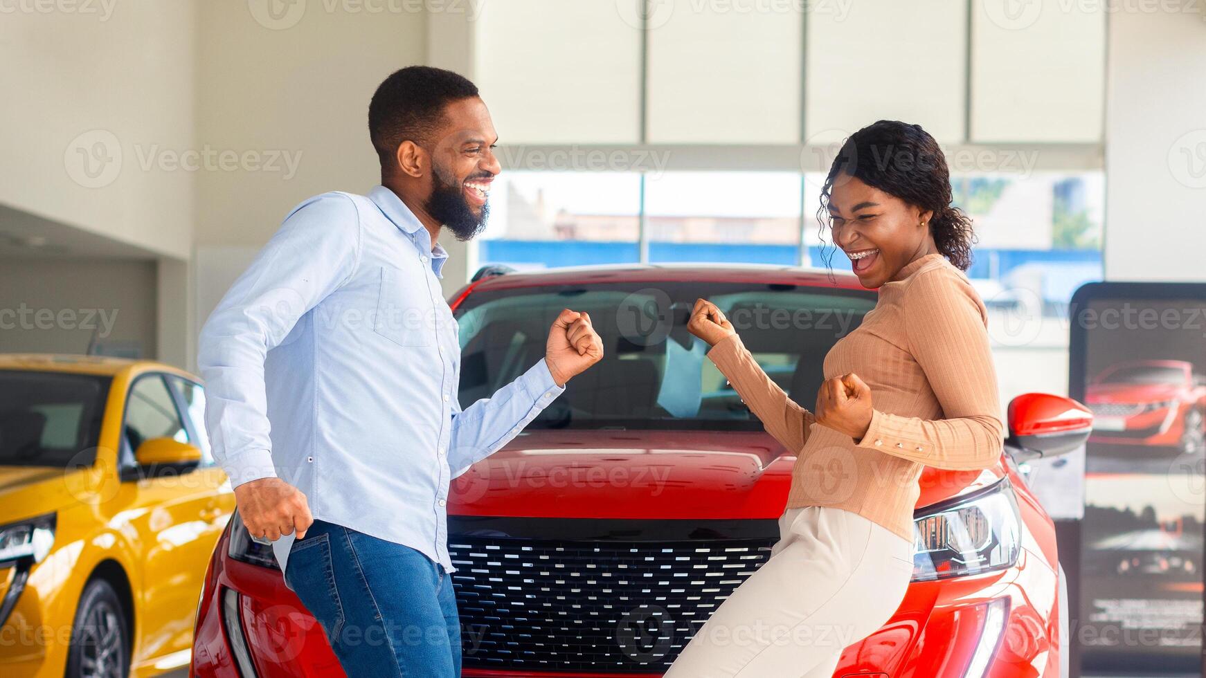 Overjoyed Black Couple Celebrating Buying New Car, Dancing In Dealership Office. Happy African American Spouses Having Fun In Auto Salon, Emotionally Reacting To Automobile Purchase, Free Space photo