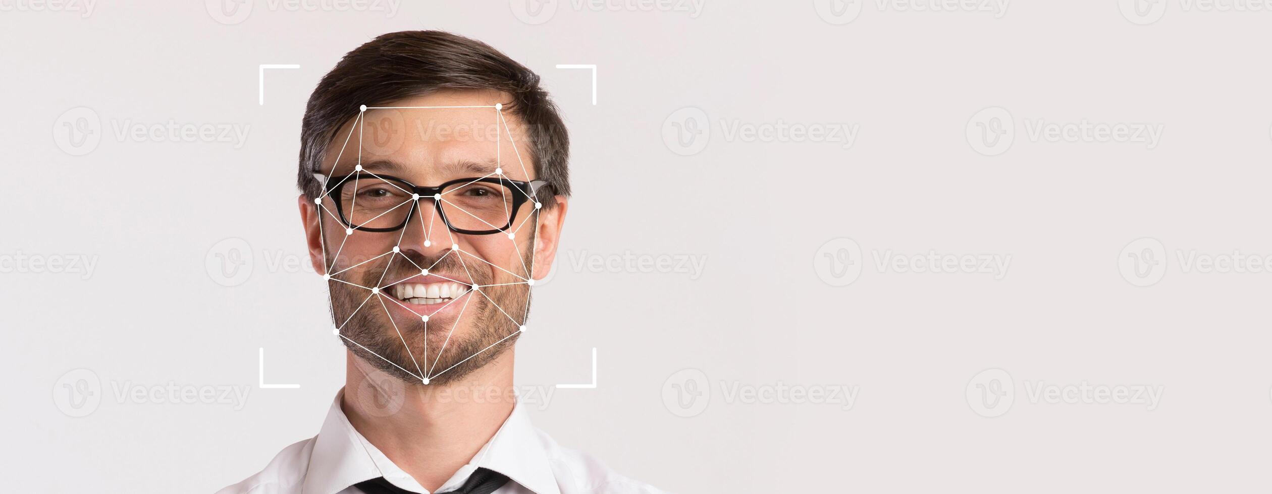 A smiling man with glasses is featured prominently on a blank background, highlighting facial recognition technology. His expression conveys friendliness in a professional context. photo
