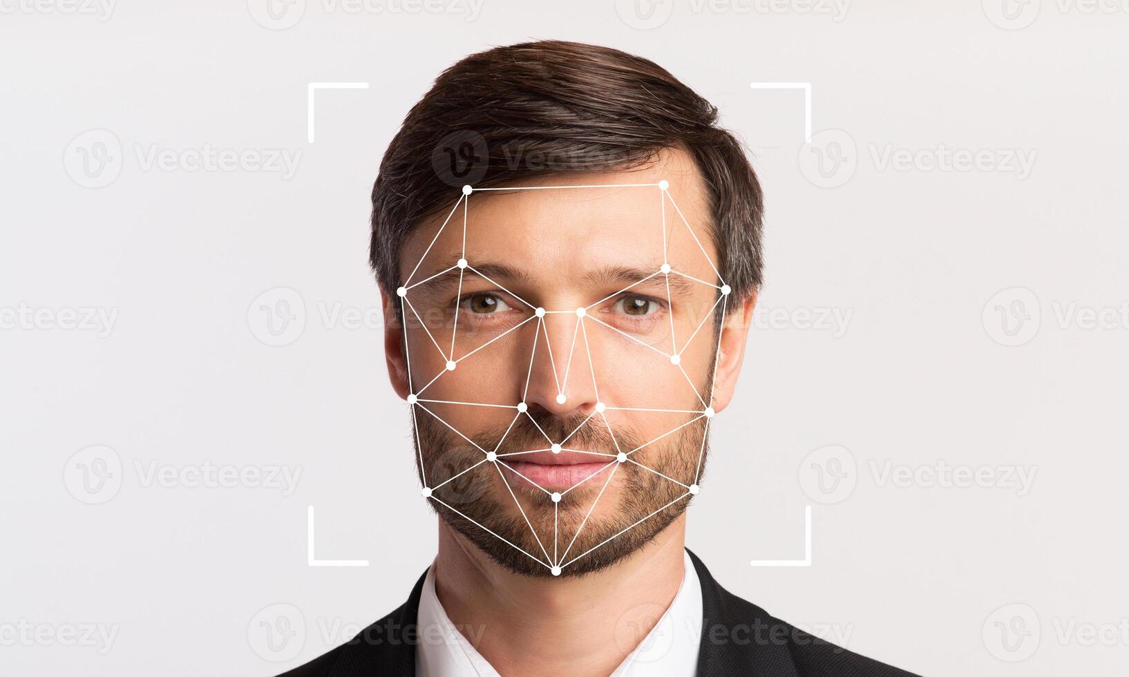 A man in formal attire is positioned against a neutral background, with facial recognition markers overlaid on his face. The technology highlights individual identification capabilities. photo