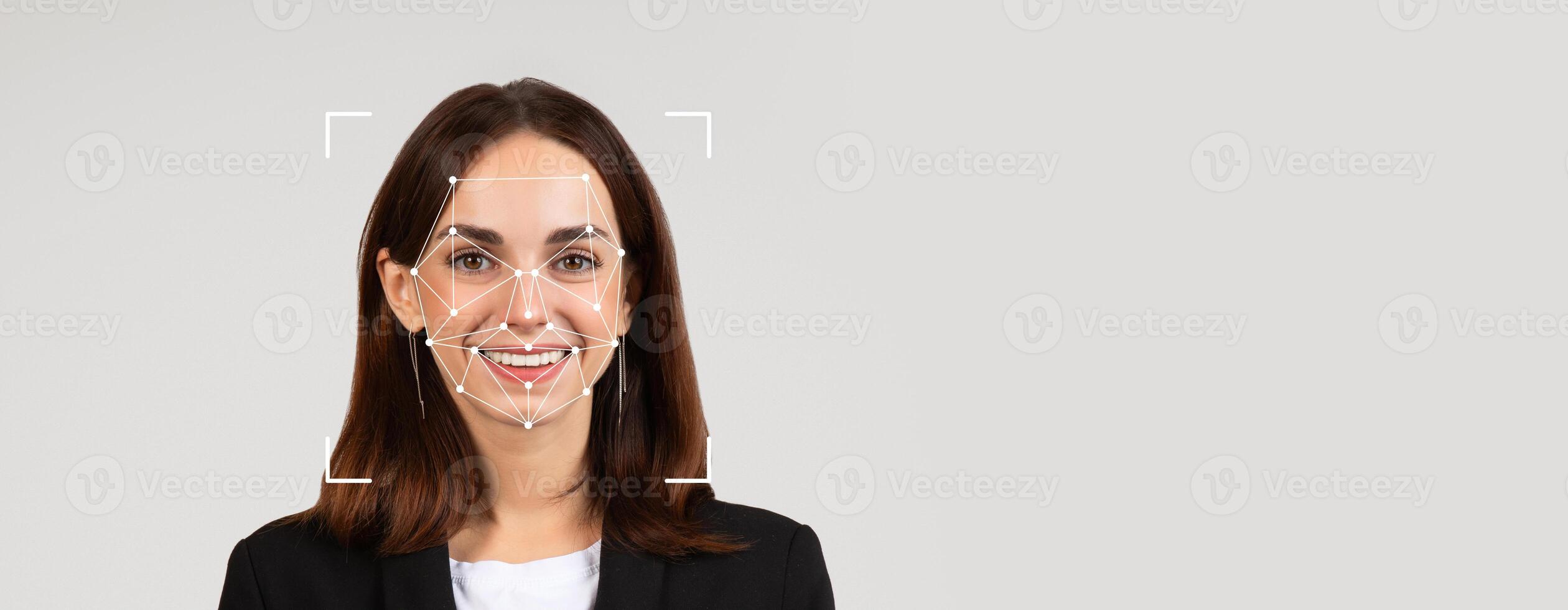 A woman smiles confidently while facial recognition technology scans her features. The neutral background enhances the focus on her expression and the technology used for identification. photo