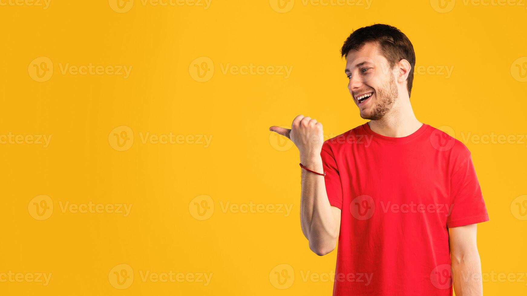 Cool Offer Concept. Portrait Of Excited Young Smiling Man Pointing Finger Aside At Copy Space Isolated Over Blue Studio Background. Emotional Male Model Indicating Free Space, Banner photo