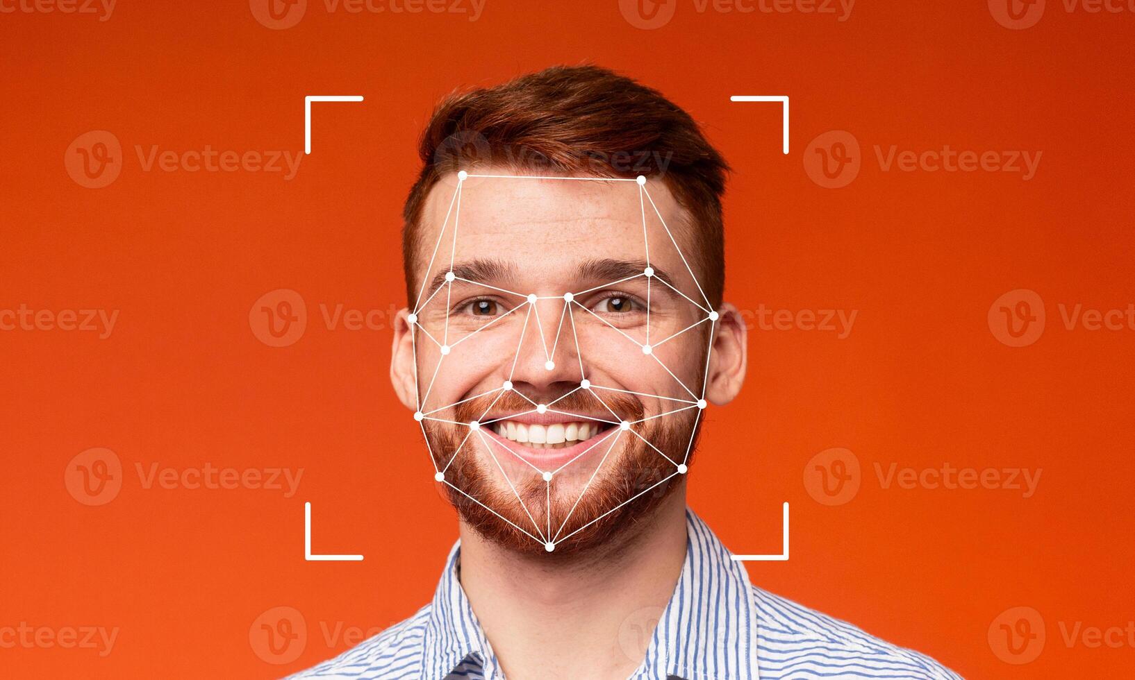 A young man smiles confidently while facial recognition technology scans his features against an orange background. The high-tech identification is evident and illustrative of modern advancements. photo