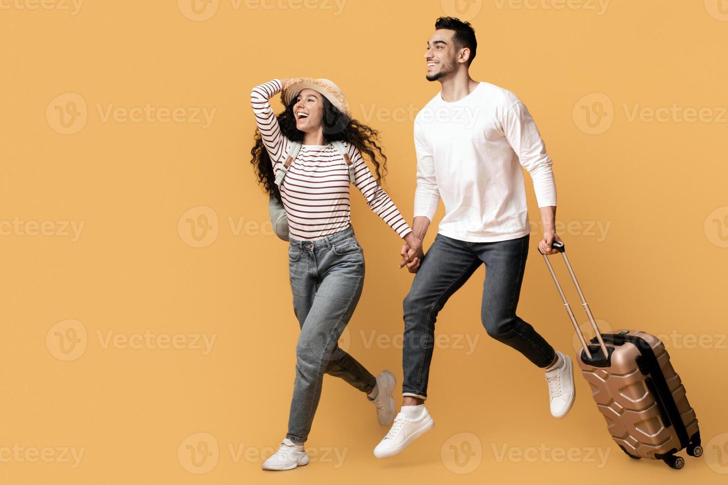 Travel Ad. Excited Young Middle Eastern Couple Running With Suitcase And Looking Aside At Copy Space On Yellow Background, Cheerful Arab Spouses Carrying Luggage, Ready For Vacation Trip, Panorama photo