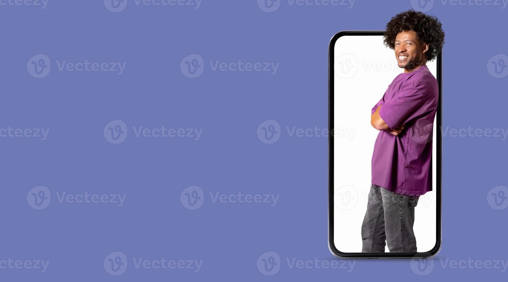 A person stands confidently with crossed arms, appearing as if coming out of a large smartphone screen. The background is blank and emphasizes the focus on technology and social media interaction. photo