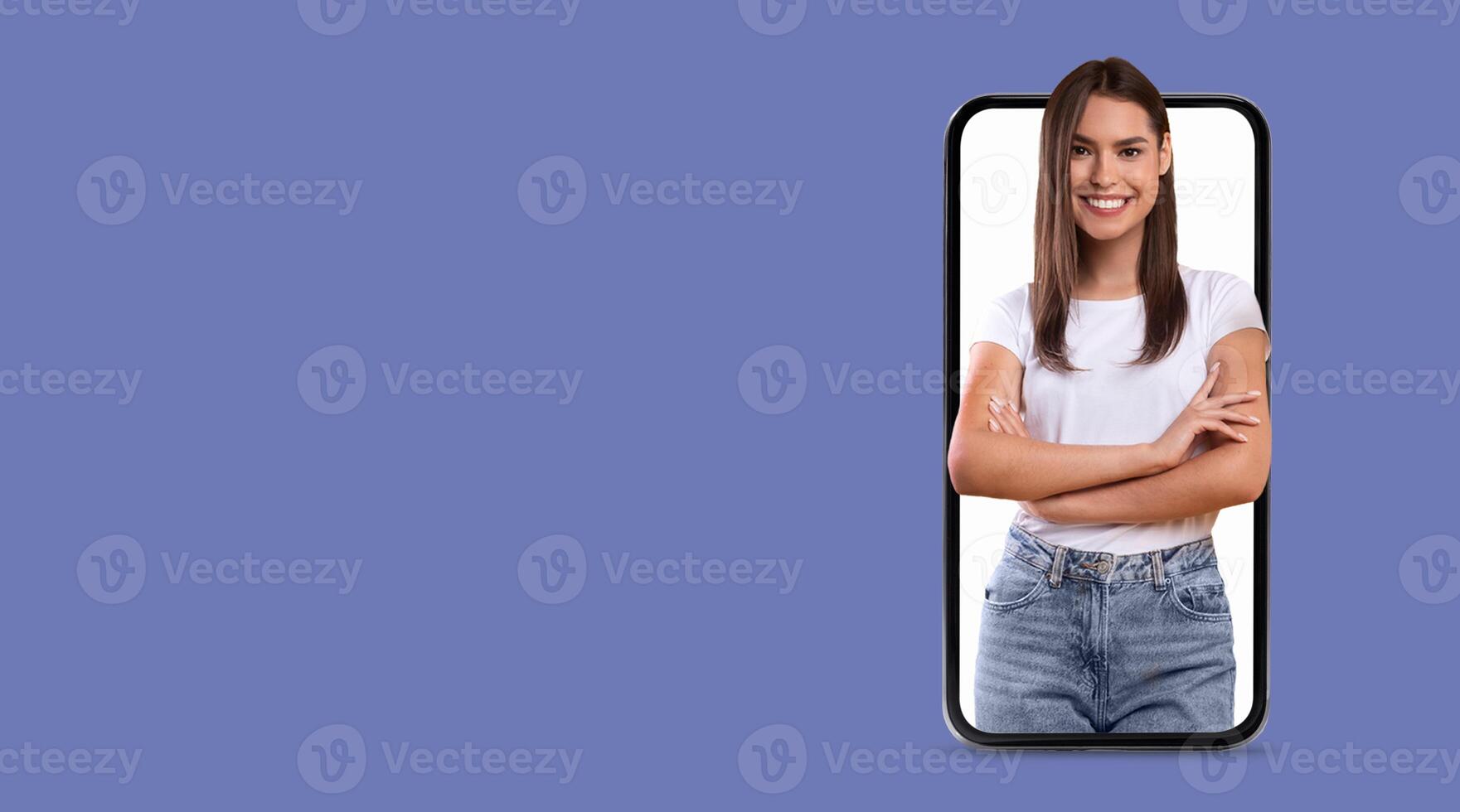 A young woman smiles confidently, with her arms crossed, displayed prominently on a smartphone screen. photo