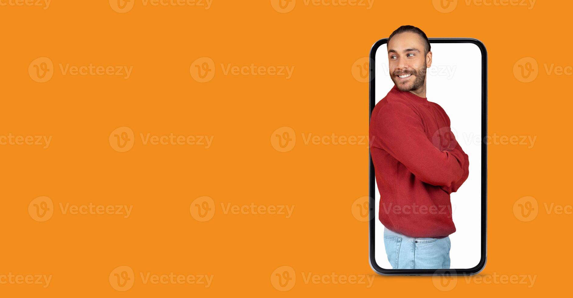 A person stands confidently with arms crossed inside a large smartphone screen. They display a joyful expression, making a connection with communication technology. photo
