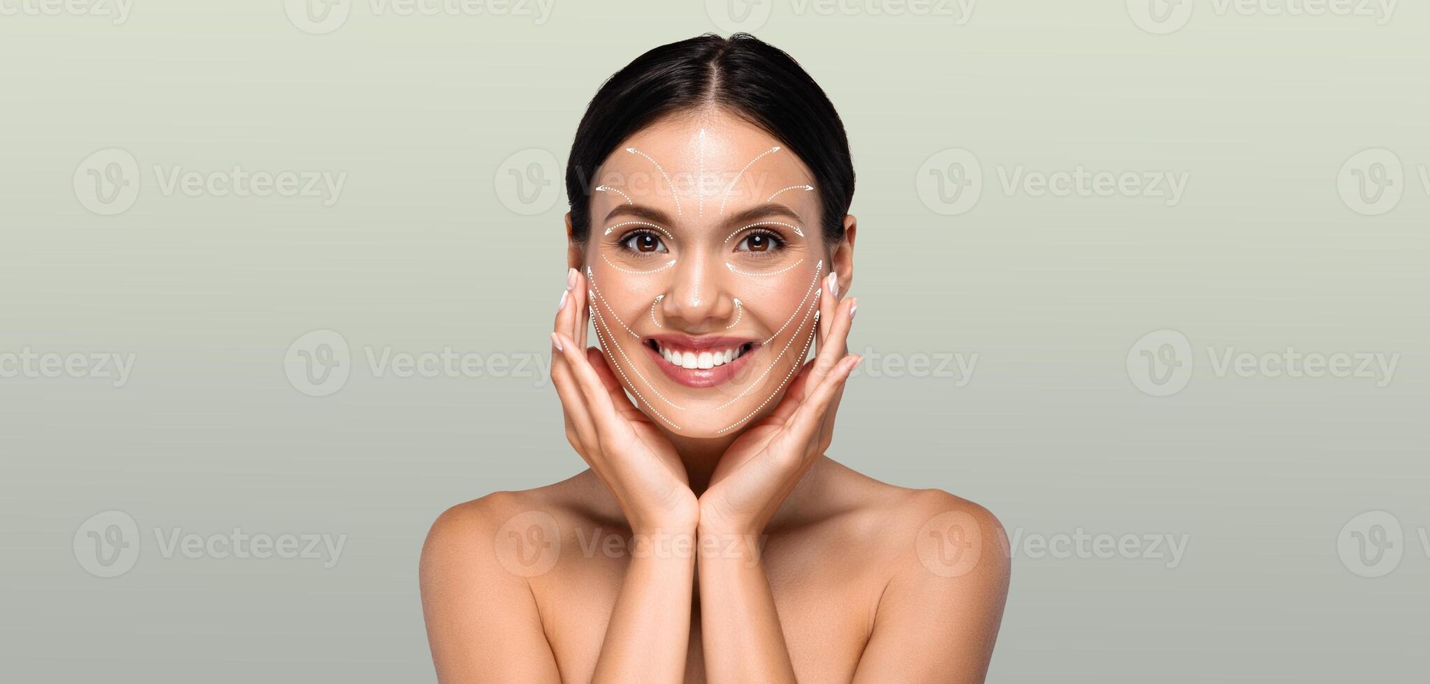 A woman engages in her skin care routine, gently touching her face with a joyful expression. The calm atmosphere highlights her commitment to beauty and self-care. photo