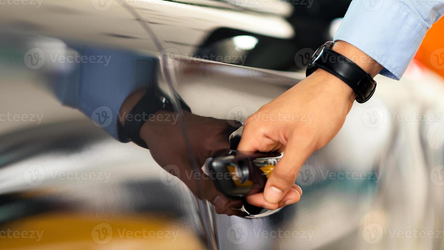 Unrecognizable man open car door, closeup of male hand with watch unlocking black auto door, making test drive at newest automobile showroom. Vehicle, transportation, car salon concept photo