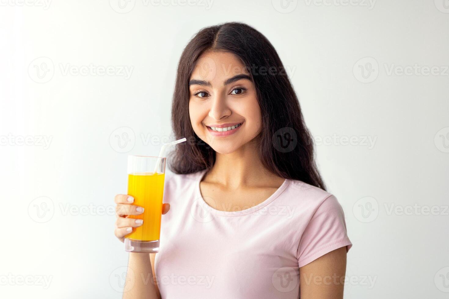 Pretty Indian woman drinking fresh fruit juice, enjoying detox beverage at home, copy space. Slim Eastern lady having tasty drink indoors. Healthy living and wellbeing concept photo