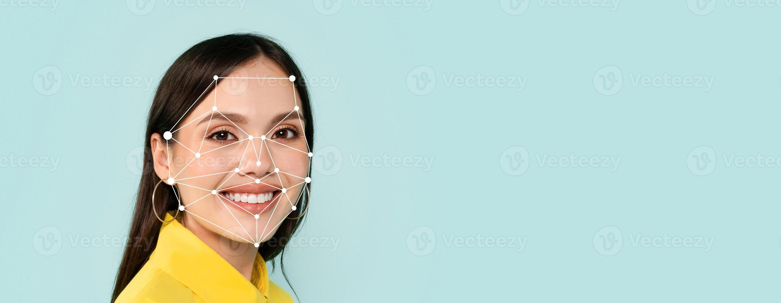 A person with long dark hair smiles confidently while facial recognition markers are visible on their face. The background is light blue, creating a clean and modern look. photo
