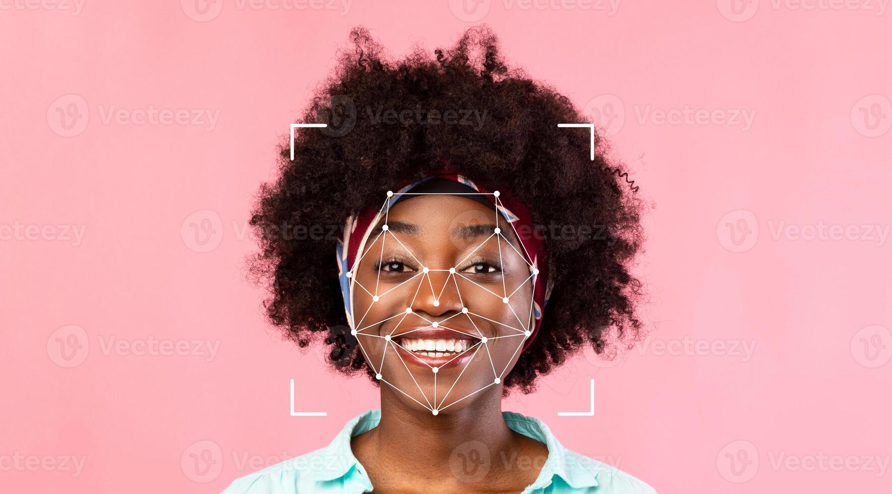 A person with a joyful expression stands against a pink background. Facial identification technology analyzes their features while they smile, showcasing advanced recognition capabilities. photo