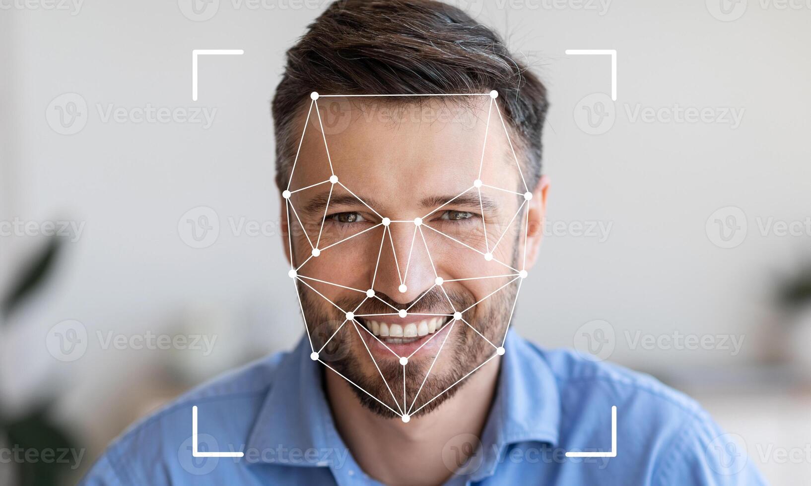 A man is smiling while a facial recognition system maps his features. The setting is bright and modern, providing an excellent backdrop for technology demonstration. photo