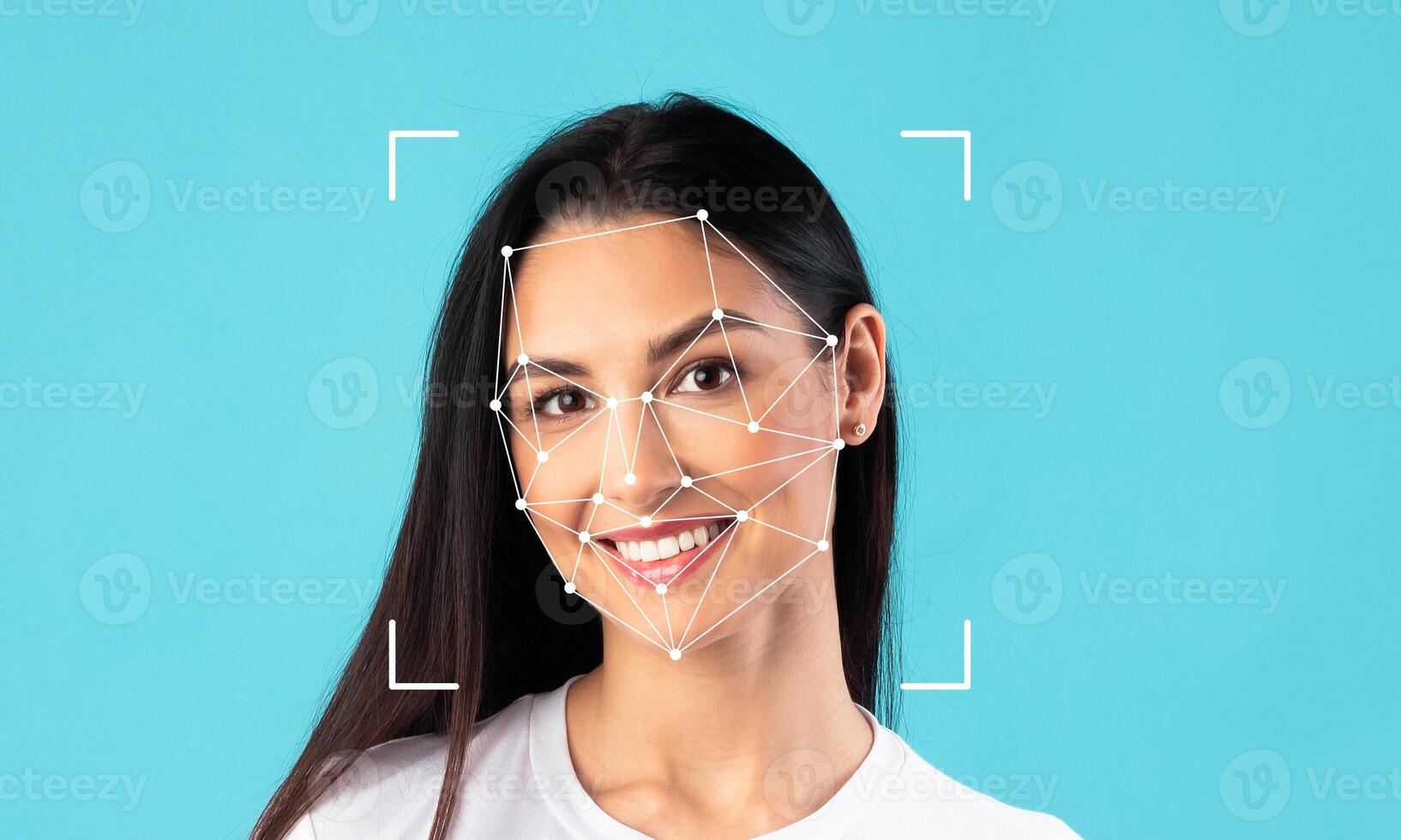 A young woman with long dark hair smiles brightly, her face framed by a blue background. Facial recognition technology highlights her features, emphasizing identification capabilities. photo