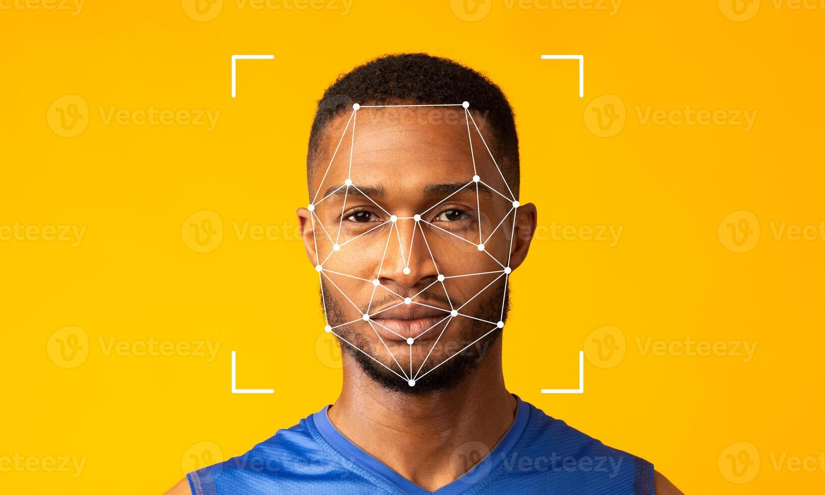 A man poses against a vibrant yellow background while facial recognition technology is applied to his face. The geometric overlay illustrates digital identification features. photo