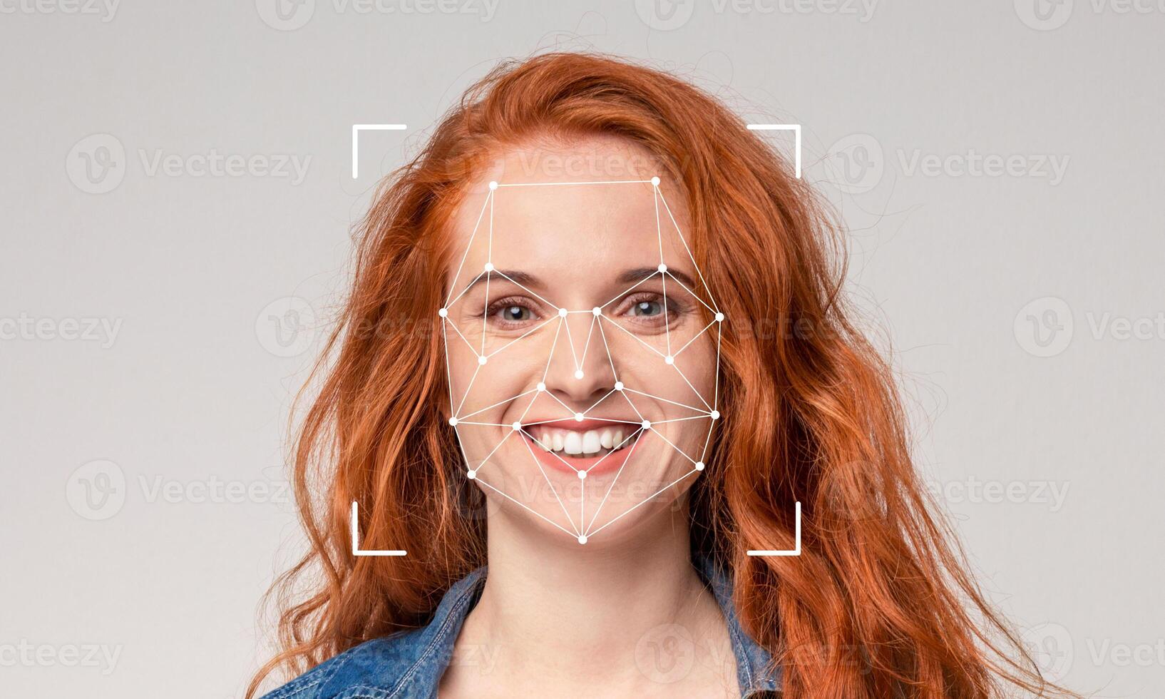 A woman with vibrant red hair is smiling warmly. Her facial features are being analyzed using advanced recognition technology marked with geometric shapes, emphasizing identification. photo