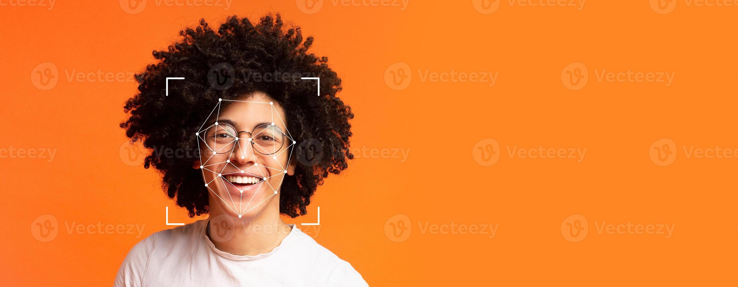 A person with curly hair smiles brightly against an orange background. Facial recognition technology overlays an outline on their face, highlighting advancements in identification. photo