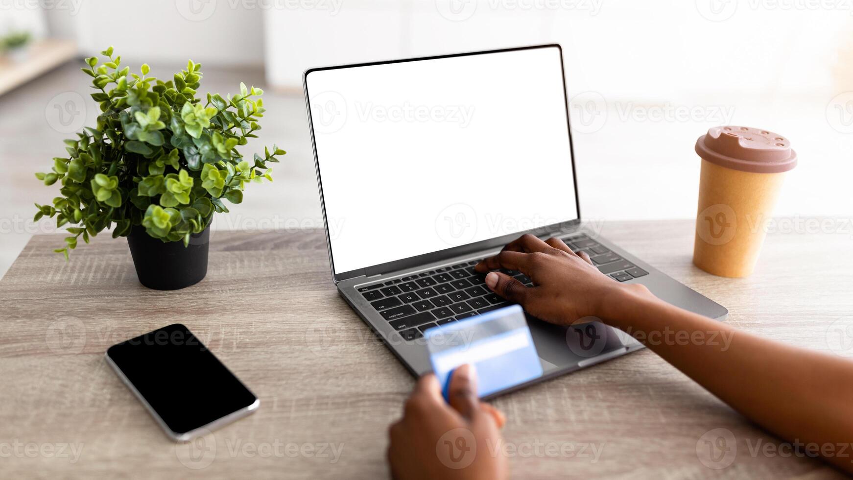 Remote shopping concept. Closeup of black lady with credit card, laptop and smartphone buying online, mockup for website or app. Unrecognizable Afro woman purchasing goods in internet, empty space photo