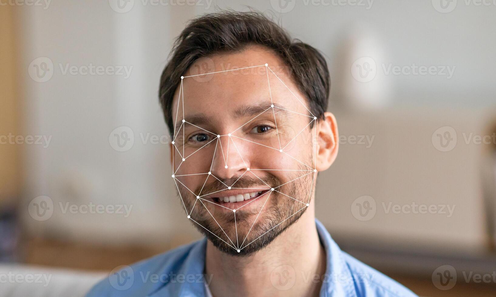 A man sitting in a modern environment smiles as facial recognition technology analyzes his features. The background is blurred, highlighting the focus on facial identification. photo